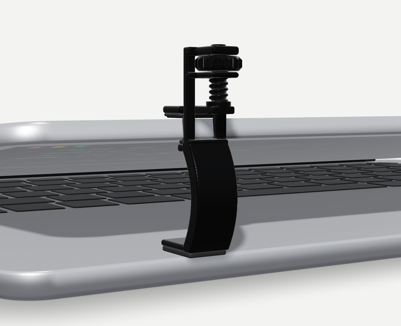 Propt Clip, a black adjustable clip, holding a silver laptop's lid open